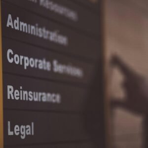 Close-up of an office directory sign showing administration and legal departments.