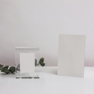 Elegant minimalist mockup featuring blank cards and acrylic frame on a white surface, ideal for presentations.