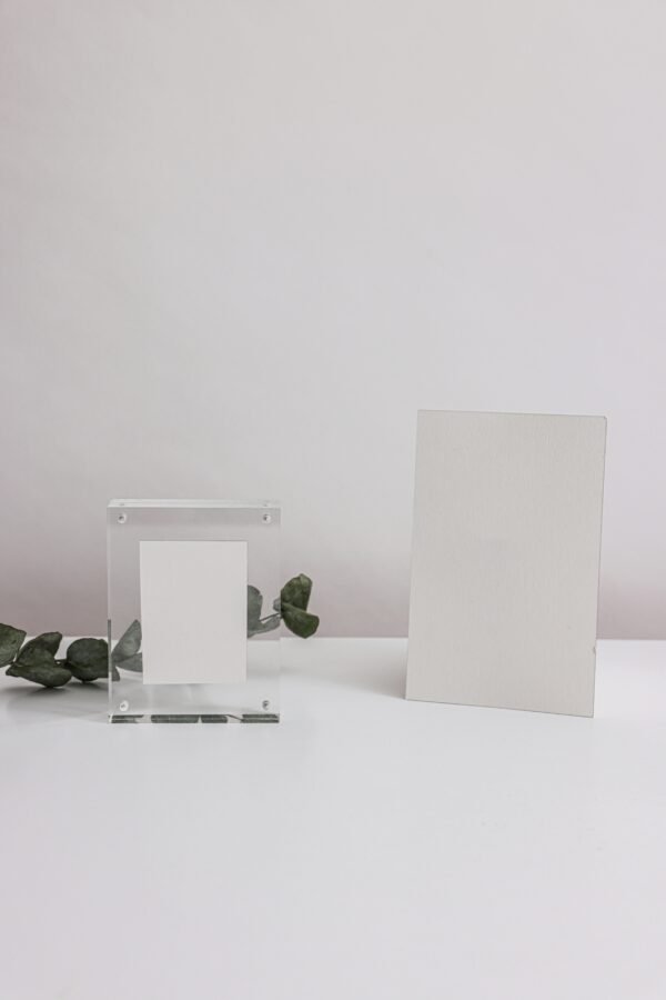 Elegant minimalist mockup featuring blank cards and acrylic frame on a white surface, ideal for presentations.